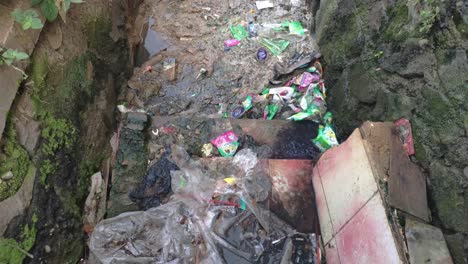 polluted and clogged sewer full of plastic trash with no water flow