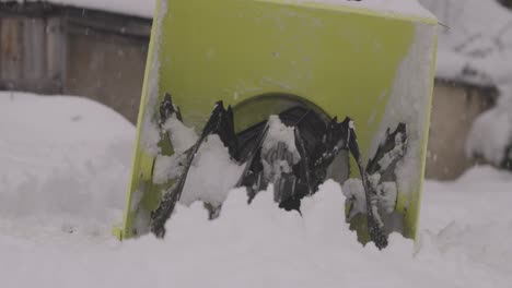 watch a yellow snowblower in slow-motion as it clears snow from sidewalks and driveways