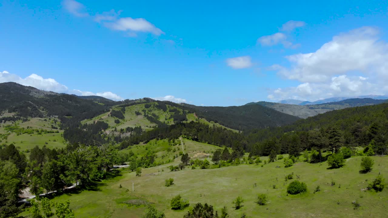 paisaje paradisíaco con prados verdes y bosques de pinos en las montañas en un día de primavera con cielo nublado
