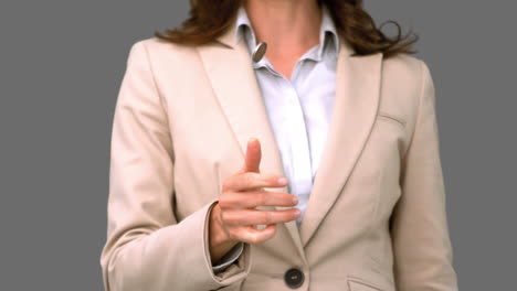 Pretty-businesswoman-throwing-a-coin-on-grey-screen