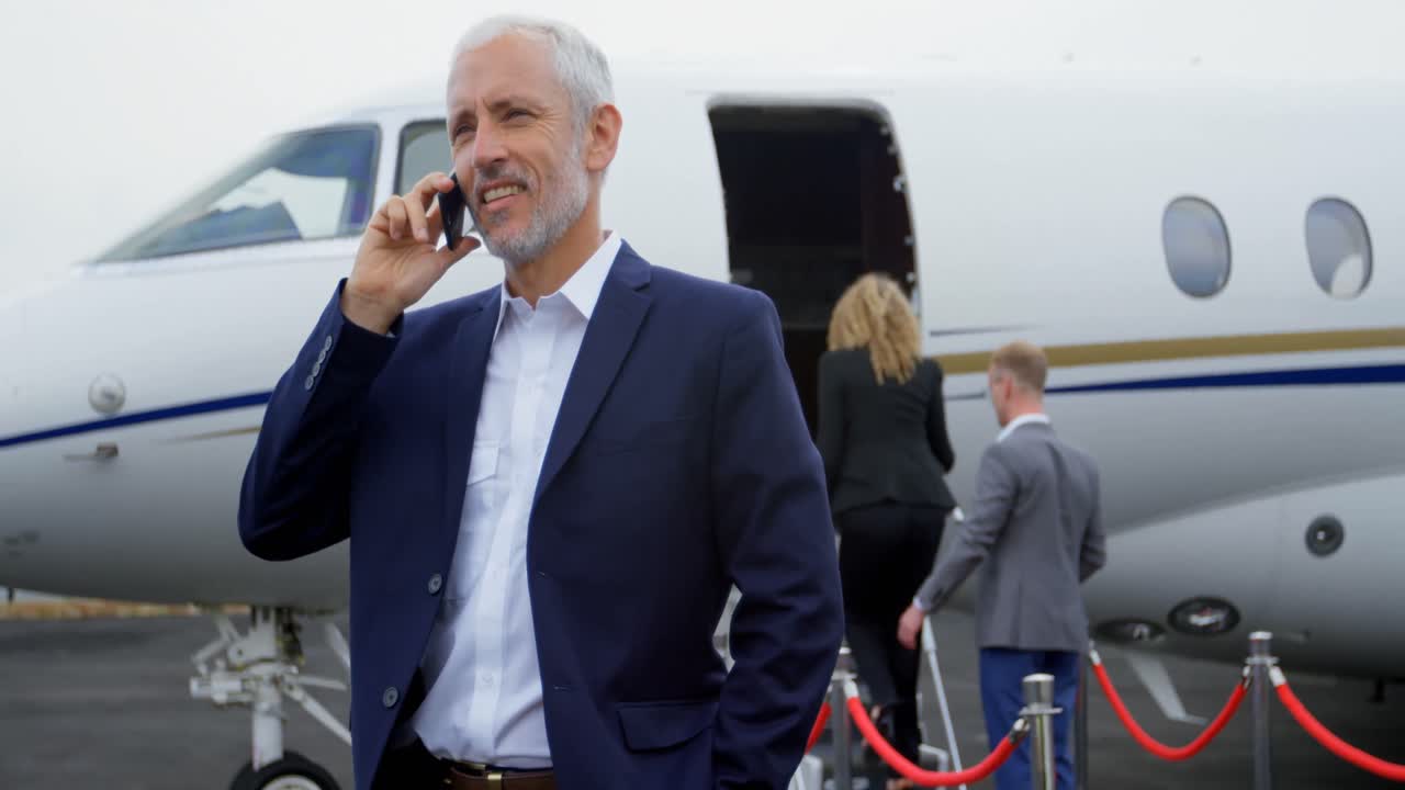 hombre de negocios hablando por teléfono móvil en la terminal 4k