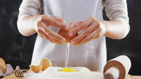 woman breaking eggs in the flour 4k