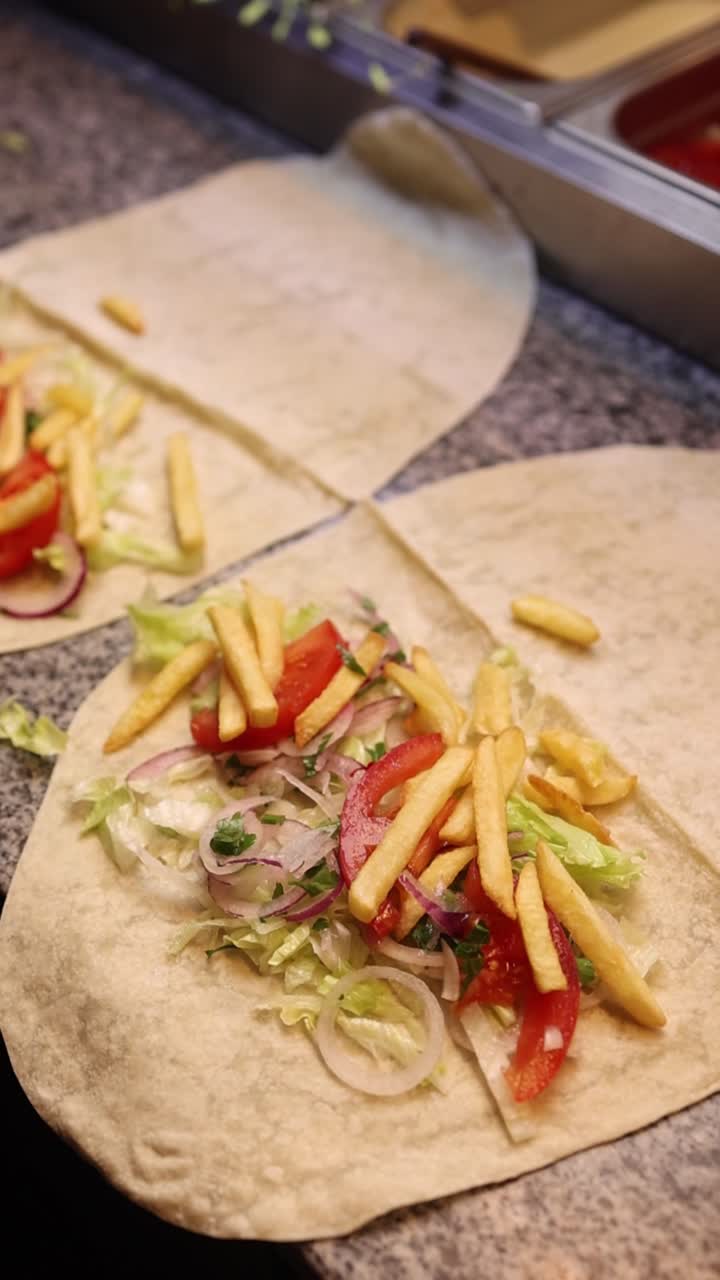 Wrap with french fries, tomato, lettuce and onion