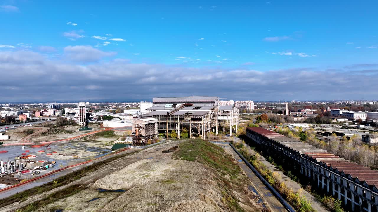 Aerial drone view of industrial archaeology in Milan, Italy. Focus on abandoned factories, old railway yards, or disused structures, symbolizing urban decay and potential reconversion