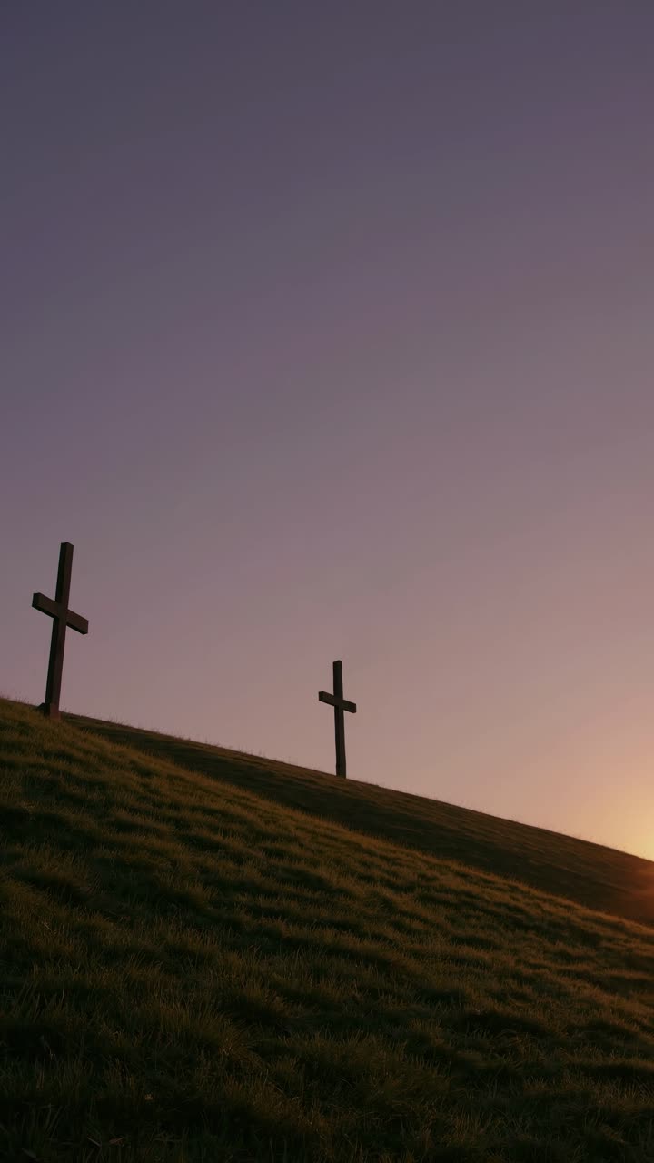Silhouetted crosses on a hill at sunset, captured from a low angle