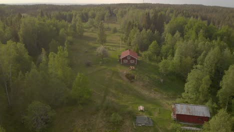 Drone-Volando-Lejos-De-Una-Pequeña-Cabaña-Roja