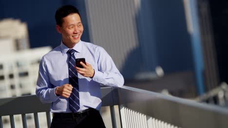 male ethnic manager on rooftop using smart phone