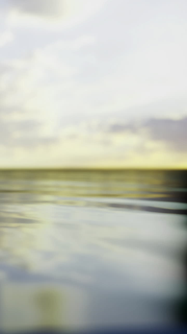 Water reflects clouds at sunset near a calm shoreline in evening light