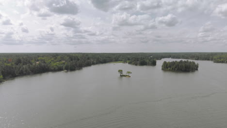 drone shot flying towards some trees on a tiny island