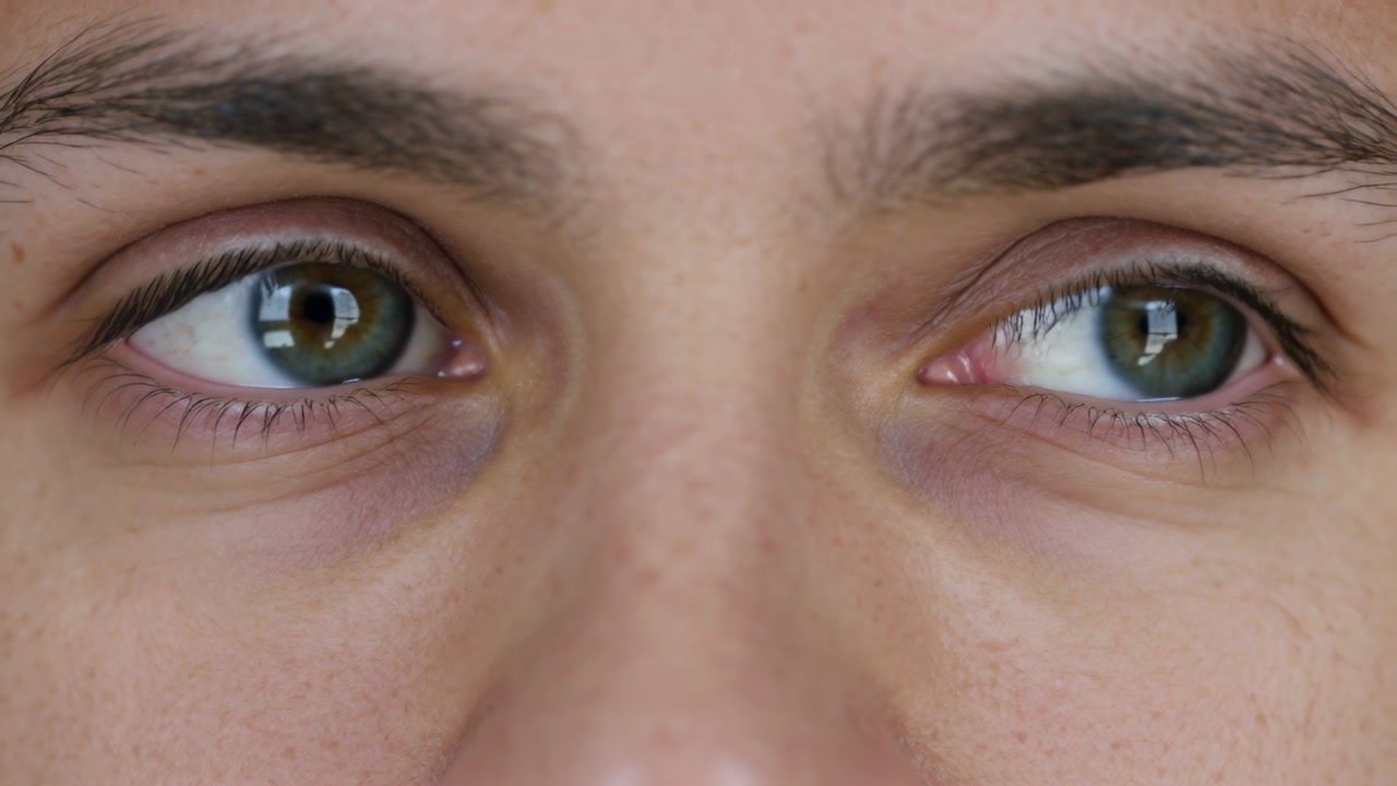 Man opening eyes from blink, scanning right then returning center, testing eye-tracking tech
