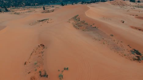 Slow-aerial-forward-tilt-up-over-uninhabitable-orange-sand-desert,-hot-dry-place