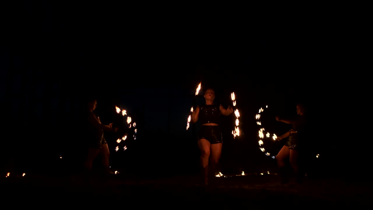 cámara lenta: actuación de fuego profesional tres mujeres con antorchas y un hombre con lanzallamas