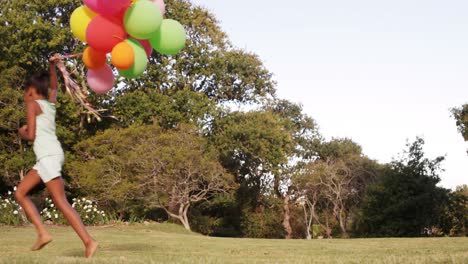 cute girl is running with balloon in a park