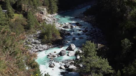 una vista de ángulo alto de un río que fluye con agua glacial en las montañas del himalaya de nepal