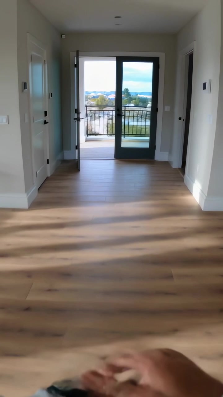 Video vertical: Operador iniciando movimiento, filmando cocina abierta hacia vista de balcón, mostrando reloj.