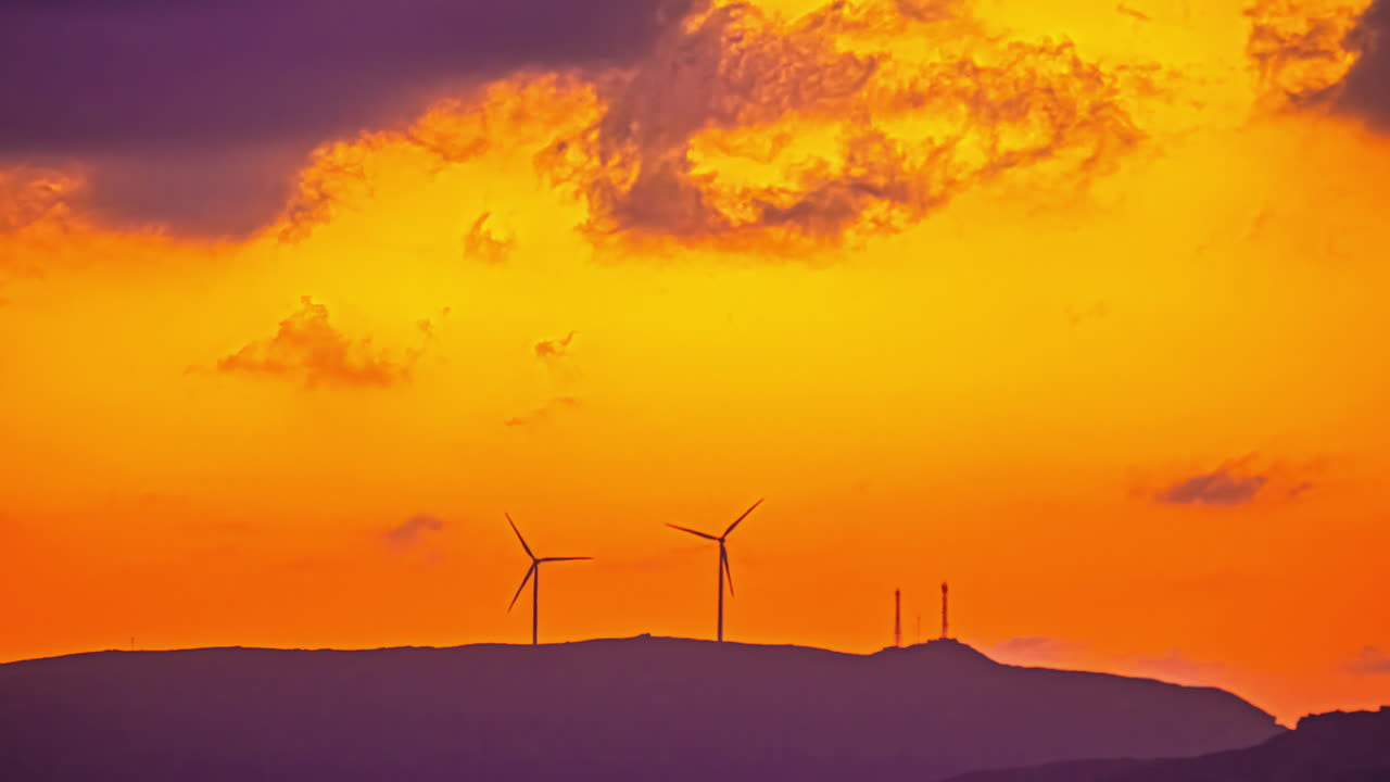Wind turbines or windmills generate efficient, clean, electrical power - sunset time cloudscape lapse