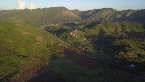 aerial descends across rice field toward hilltop jungle villa, lombok