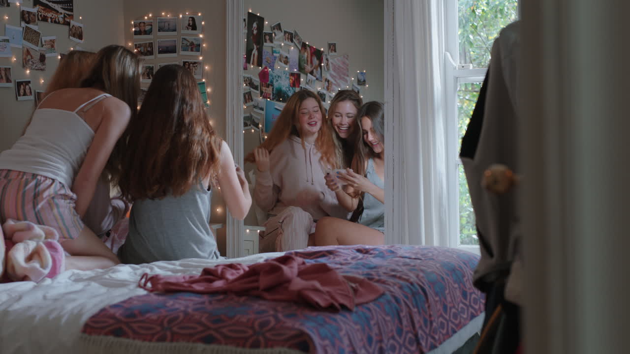 행복한 십대 소녀들이 스마트폰을 사용하여 함께 셀카 사진을 찍고 가장 친한 친구들이 포즈를 취하고 얼굴을 짓는 것을 즐기고 집에서 주말을 소셜 미디어에서 공유합니다.
