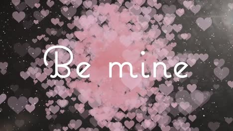 be mine text banner against multiple pink heart icons floating against black background