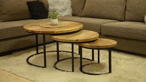 beautiful round wooden coffee table with smaller parts inside furniture store.