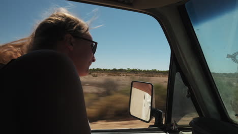 Young-woman-raising-hand-out-of-window-and-feeling-free-during-bus-ride-in-Australia