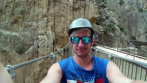 selfie view walking on cable bridge amidst rocky cliffs over river