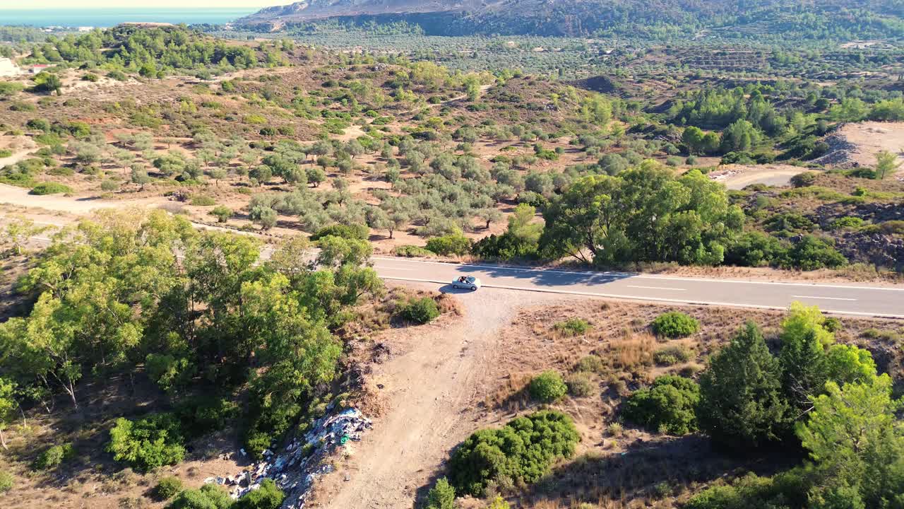 로데스의 도로와 푸른 숲과 그리스의 바 ⁇ 가 배경으로 여름 동안 드론으로 4k로 촬영되었습니다.