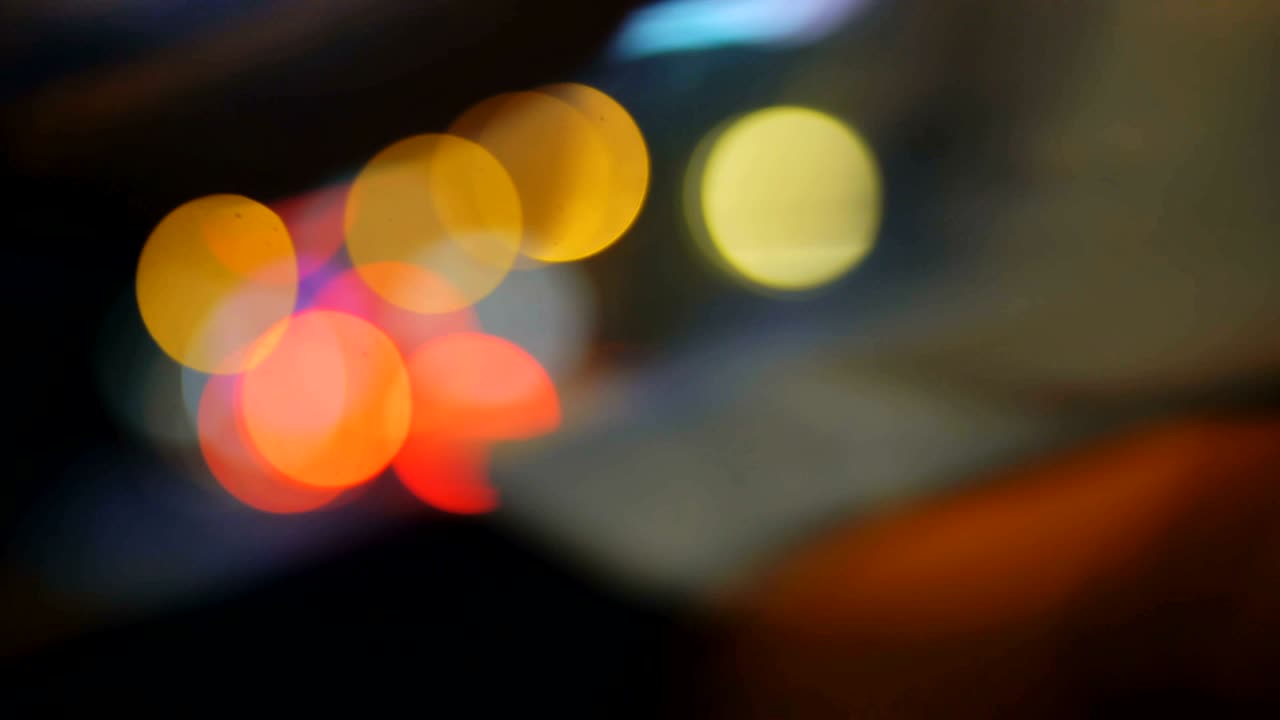 coloridos semáforos bokeh círculos en la calle de la ciudad de la noche. fondo abstracto