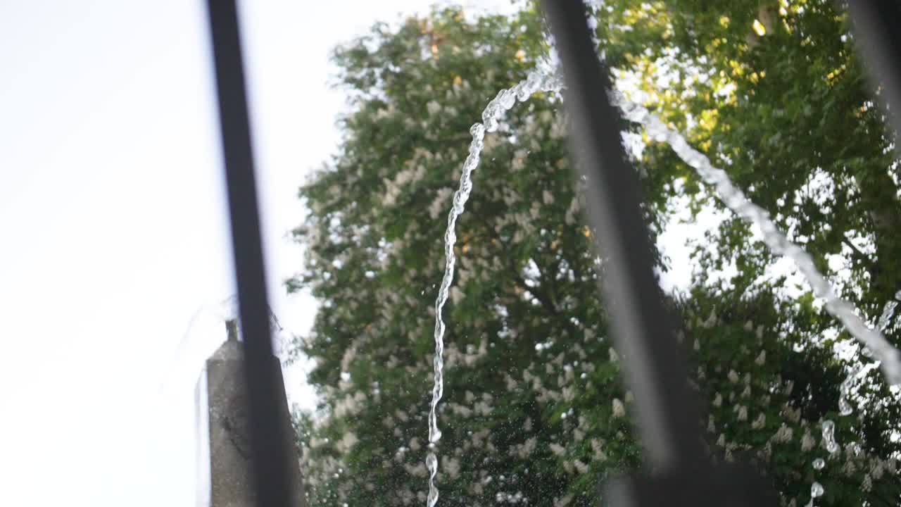 Moving shot of fountain behind fences