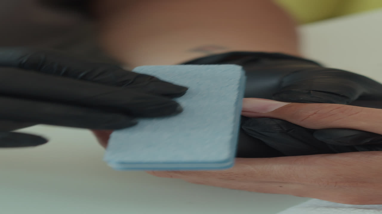 Vertical of Expert Filing Nails of Client in Studio