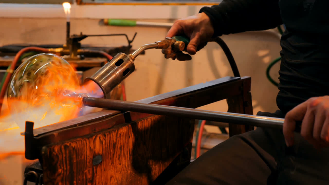 Glassblower shaping a molten glass