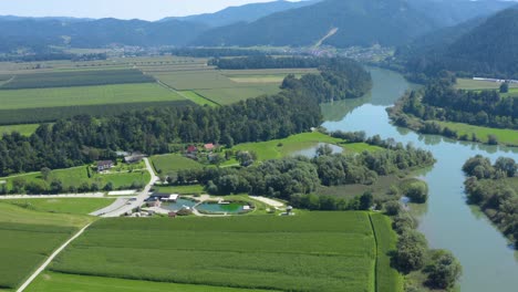 aerial view slovenia countryside with vodni park center and drava river to the right, drone approach fly over reveal shot