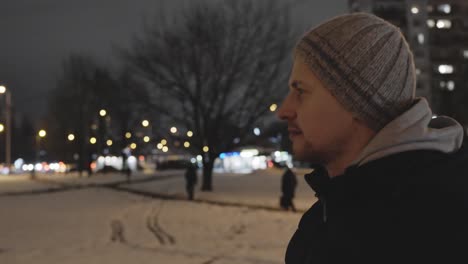 caucasian man explores city in the evening in slow motion walk, view from side