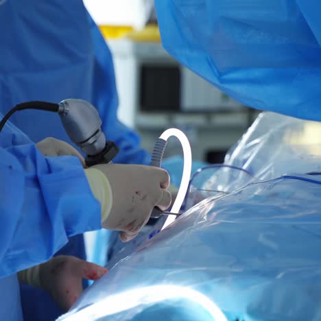 surgical instrument in doctor's hands. surgeon's hands holding a special equipment during operation on a patient. close-up