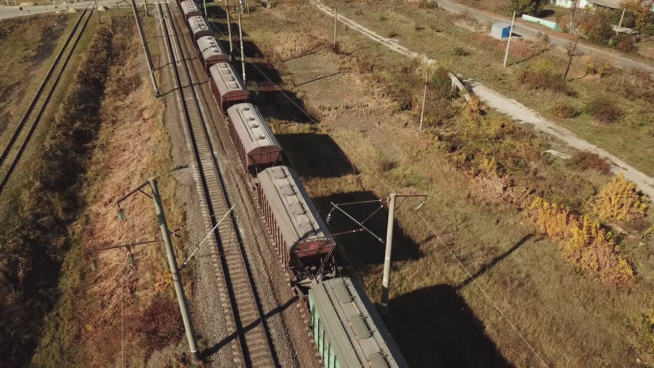 freight train is passing a highway. Aerial view of the freight train with wagons