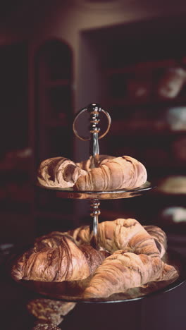 close-up of freshly baked croissants on a display stand in a bakery