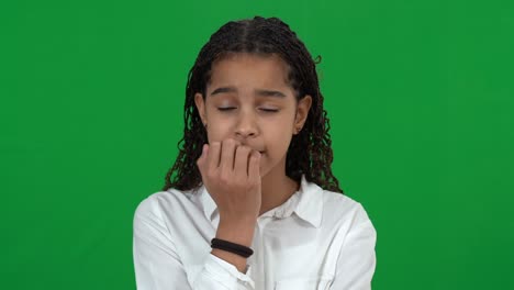 nervous african american teen girl biting nails on green screen. portrait of anxious worried teenager waiting for test results at chromakey background. worries and nervousness concept.