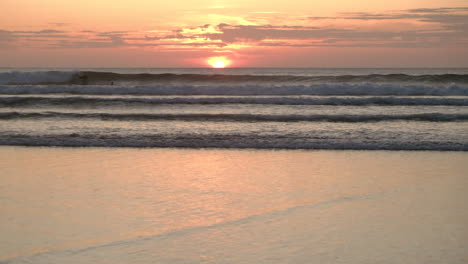 Bodyboarders-in-the-ocean-surfing-at-sunset