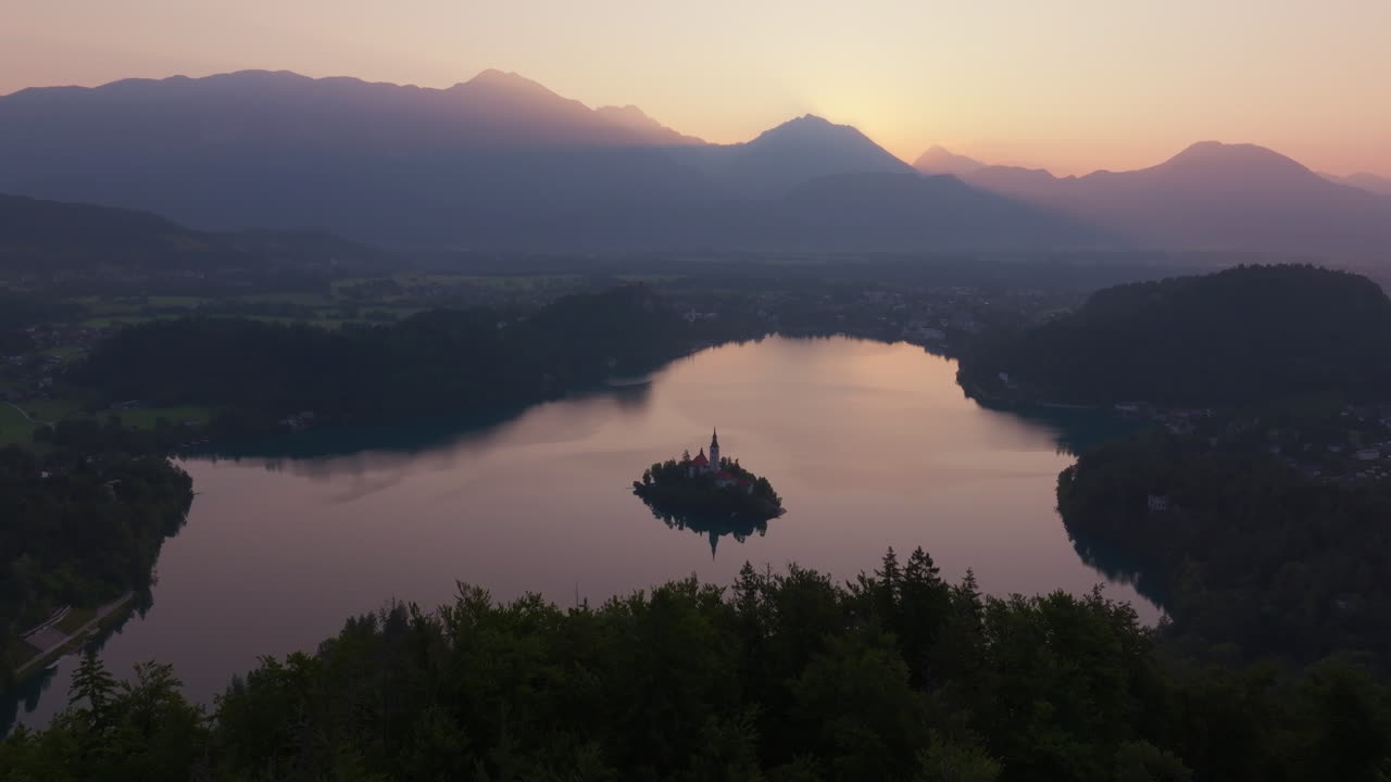 Vista aerea dell'isola del Lago di Bled circondata da boschi e montagne