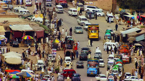 Peshawar,-Pakistan,-Aerial-view-of-busy-mountain-pass-connecting-the-Pak-Afghan-border-through-white-range-with-valley-of-Peshawar,-Truck-and-other-traffic-with-people