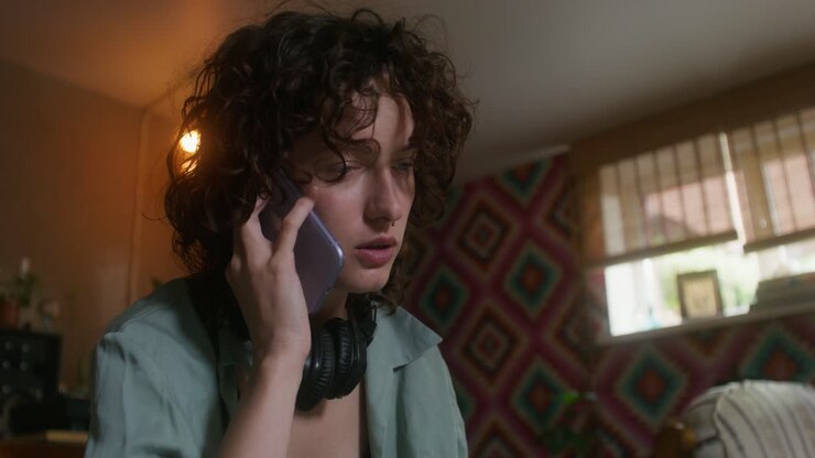 Donna al telefono in una stanza