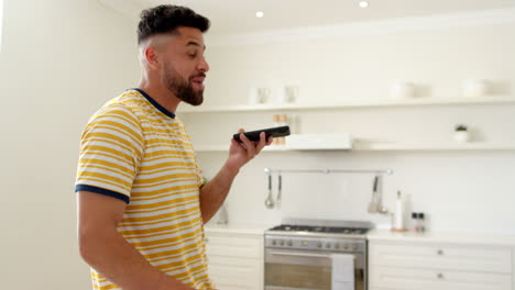 man in kitchen using smartphone for voice command, multitasking at home