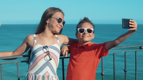 Adolescentes-Sonrientes-Tomándose-Selfie-Afuera.-Niño-Y-Niña-Haciendo-Muecas-Al-Aire-Libre.