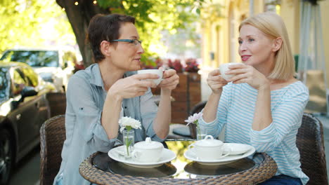 two women enjoying coffee at an outdoor cafe