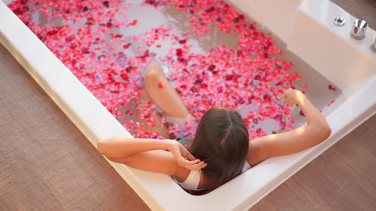 Lady enjoying a rose petal bath in peace