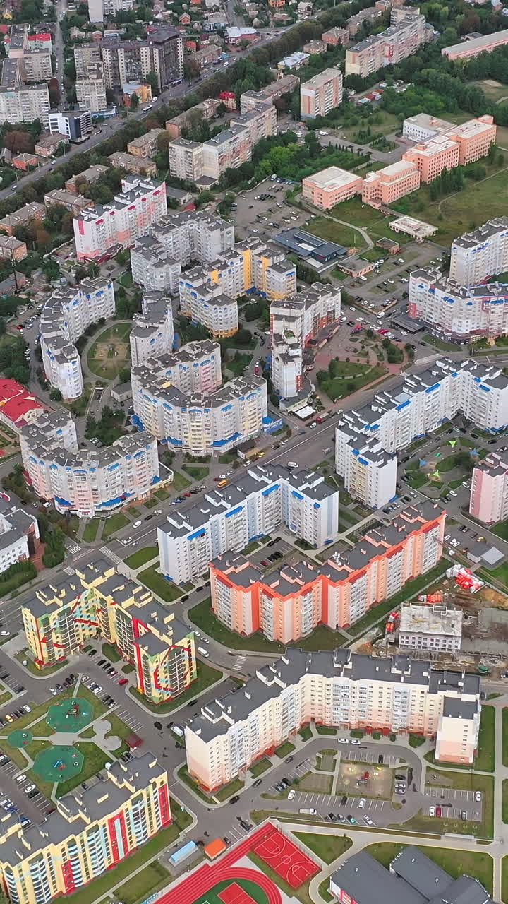 Contemporary high-rise buildings on urban background. Residential apartments for citizens in modern district. Aerial view. Vertical video