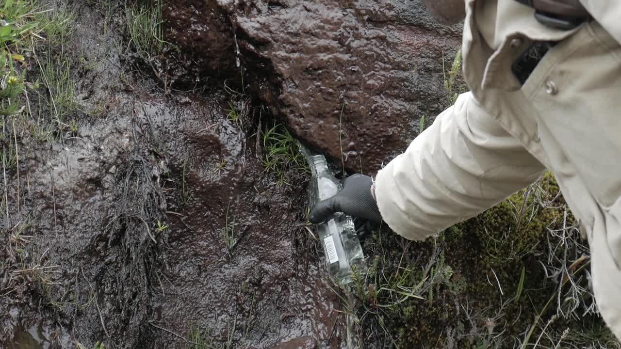 Man recollecting clean unpolluted water from paramo zone