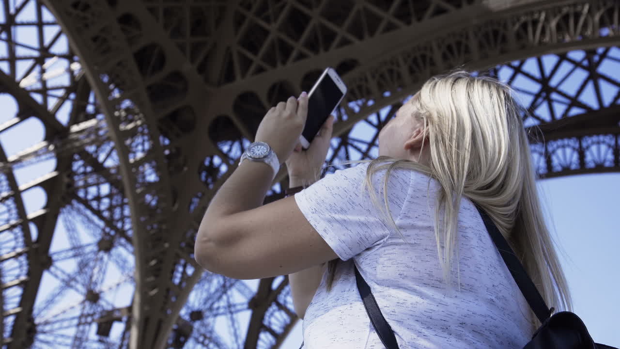 Woman taking photo of Eiffel Tower