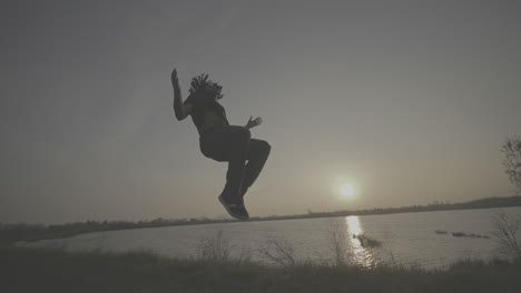 acrobatic street dancer at sunset by the river