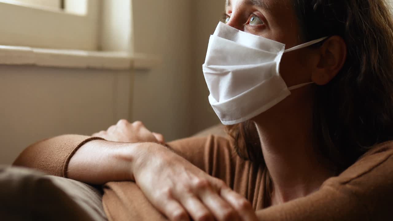 Donna caucasica che indossa una mascherina a casa